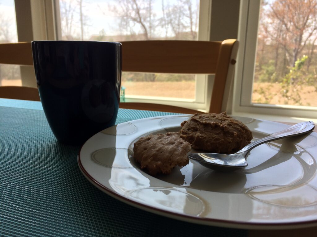 A pair of Apocalypse cookies on a plate with a mug of tea.